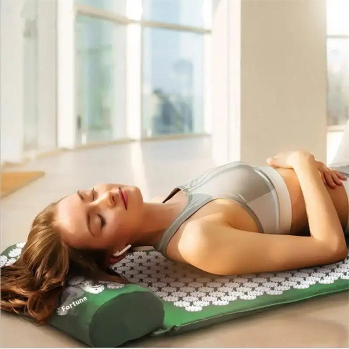 Woman lying relaxed on the acupressure mat and pillow set