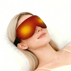 Woman relaxing in bed wearing the heated compression eye mask